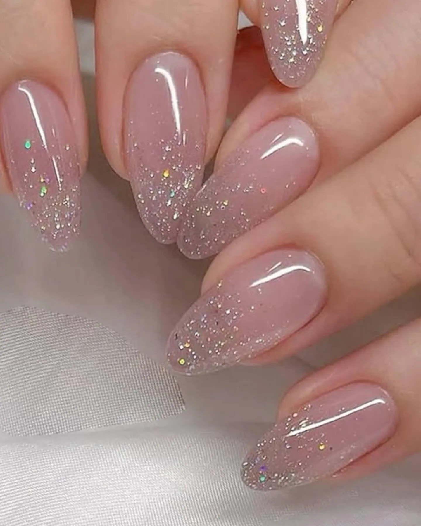 This soft pink glitter French tip look is the definition of easy, everyday elegance. A sheer blush base fades into a delicate dusting of fine, scattered glitter at the tips, creating a subtle sparkle that feels polished rather than flashy. It’s a versatile style that works beautifully for everyday wear, but it also makes a great choice for special occasions like weddings, New Year’s Eve, or parties where you want something refined with just a hint of shine.
