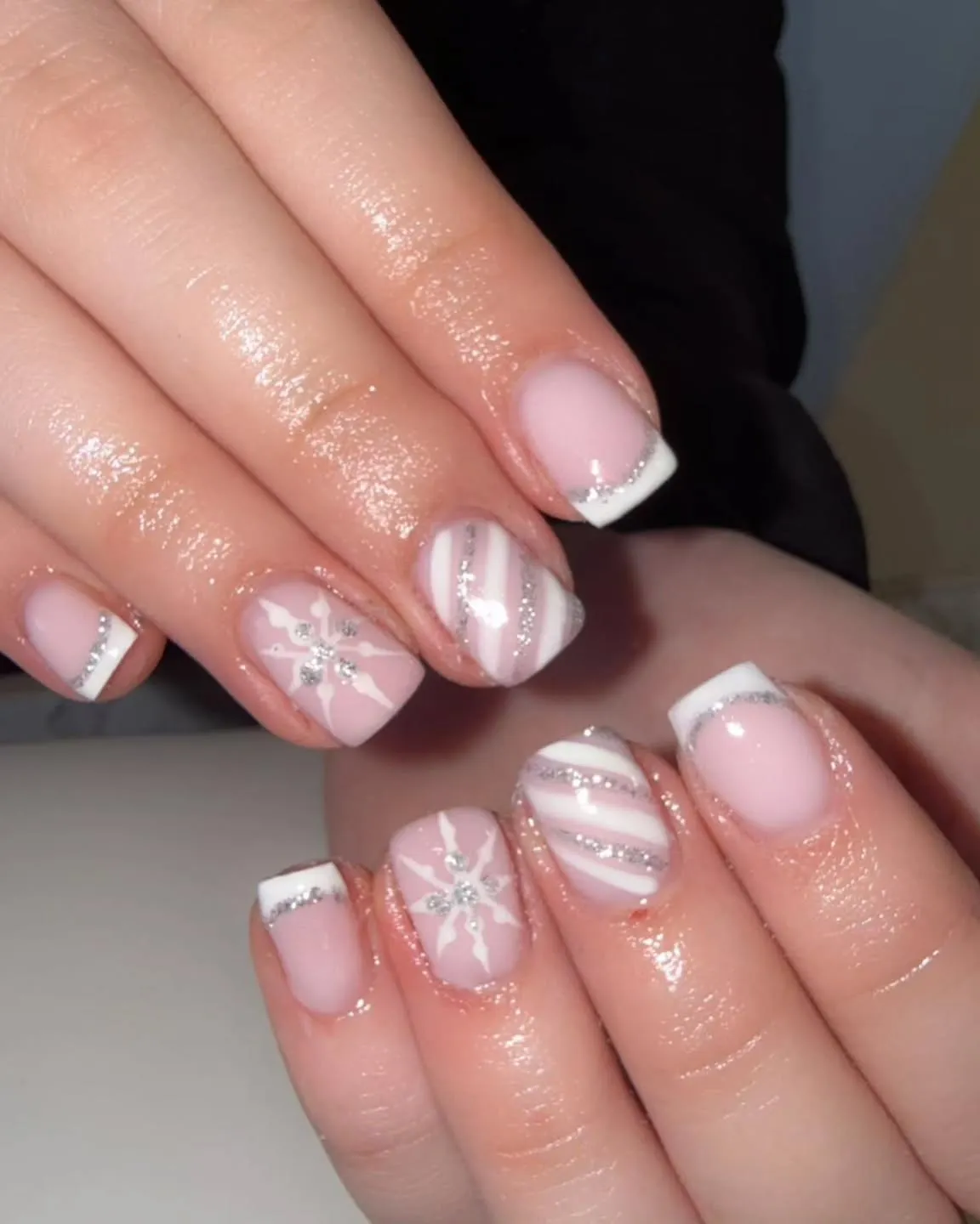 This festive French tip design leans fully into Christmas with soft pinks, snowflakes, and glittery details. A blush base and crisp white tips keep the classic French shape, while silver glitter edging, delicate snowflake accents, and tiny crystal centres give it that unmistakable winter feel. Polished but playful, this style is perfect for the holiday season—ideal for Christmas parties, winter weddings, or anyone who loves a festive manicure without going over the top.