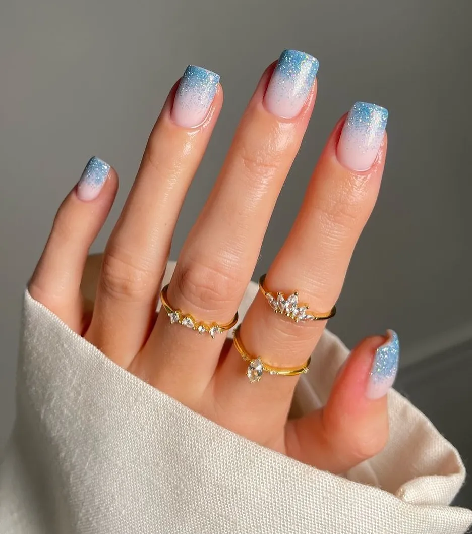 This soft blue glitter French tip design puts a cool-toned spin on the classic look. A sheer nude base fades into pale blue glitter tips, creating a clean ombré effect that feels light and modern. The subtle sparkle keeps it versatile enough for everyday wear, while the icy blue tones make it a lovely option for winter months, holiday season, or even New Year’s celebrations without feeling overly festive.