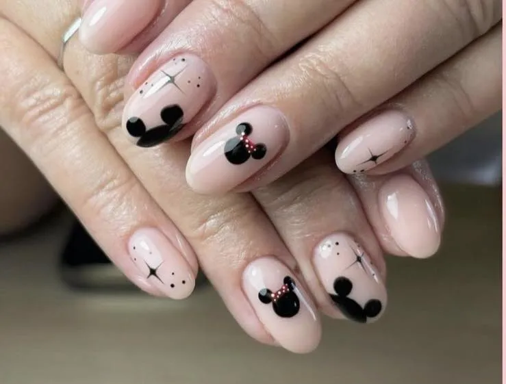 If you love subtle Disney style, these nude nails with black Mickey silhouettes and dainty red bows are perfection. Clean, classy, and ideal for Disney World trips or everyday wear.