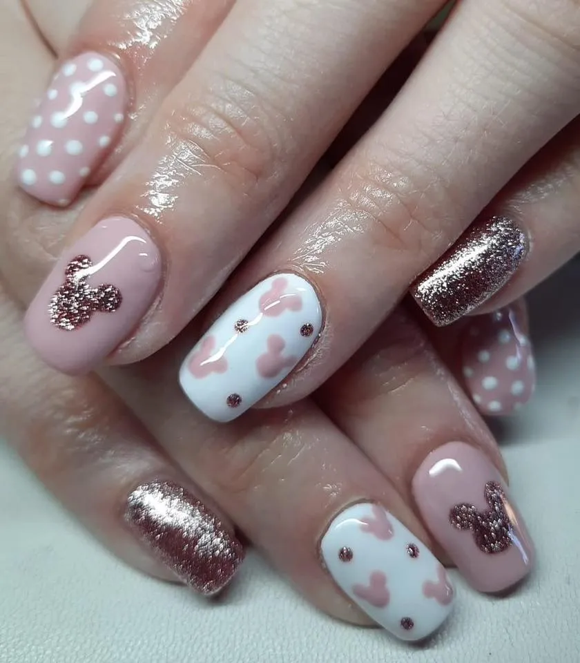 A timeless classic — these Minnie nails combine blush tones, polka dots, and glittery accents shaped like her famous bow and ears. Sweet, simple, and totally Disney chic.