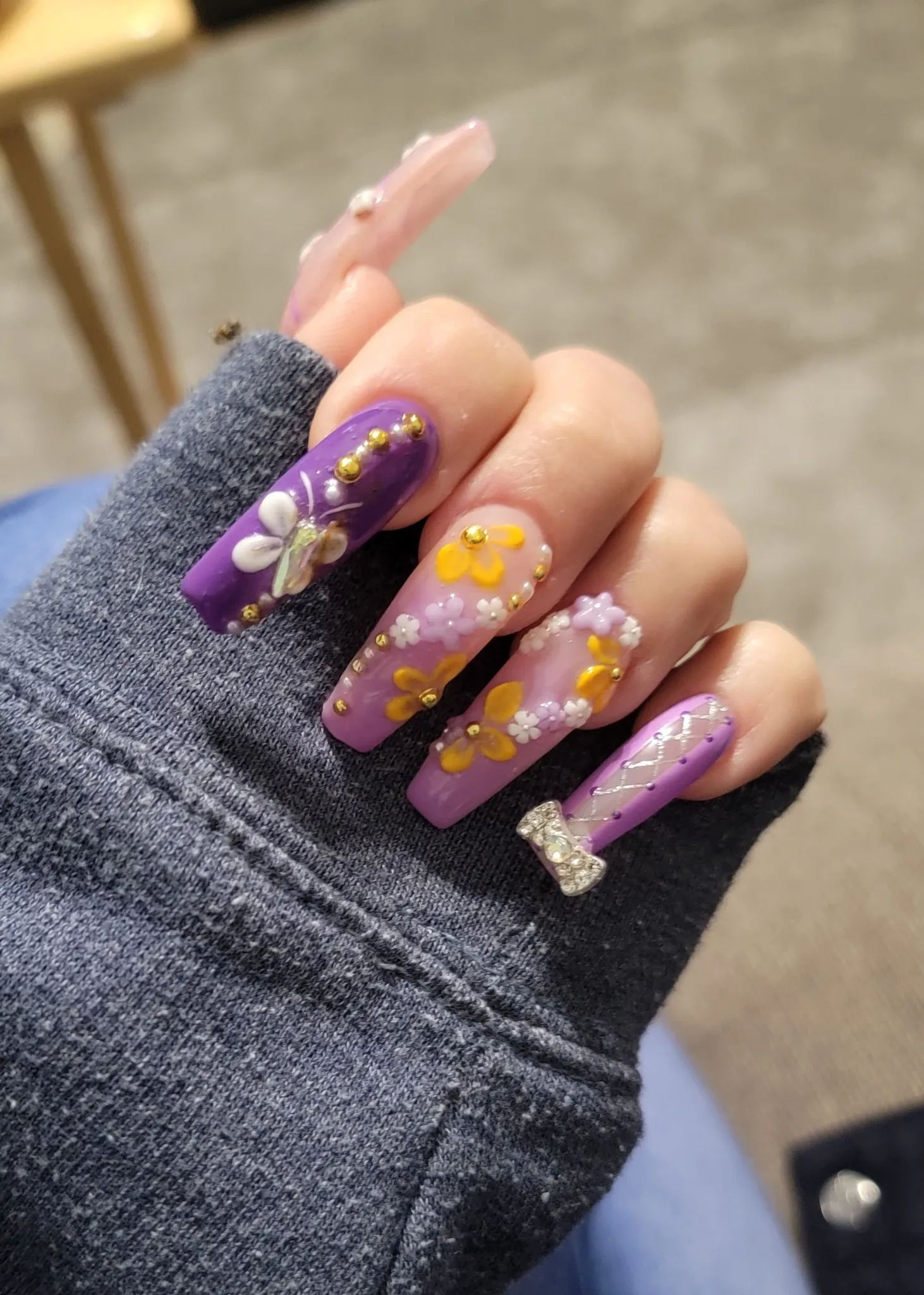 These Rapunzel nails are full of fairy-tale magic — purple polish, 3D flowers, and gold embellishments that sparkle just like her iconic lantern scene. The tiny bow detail adds the perfect princess touch.