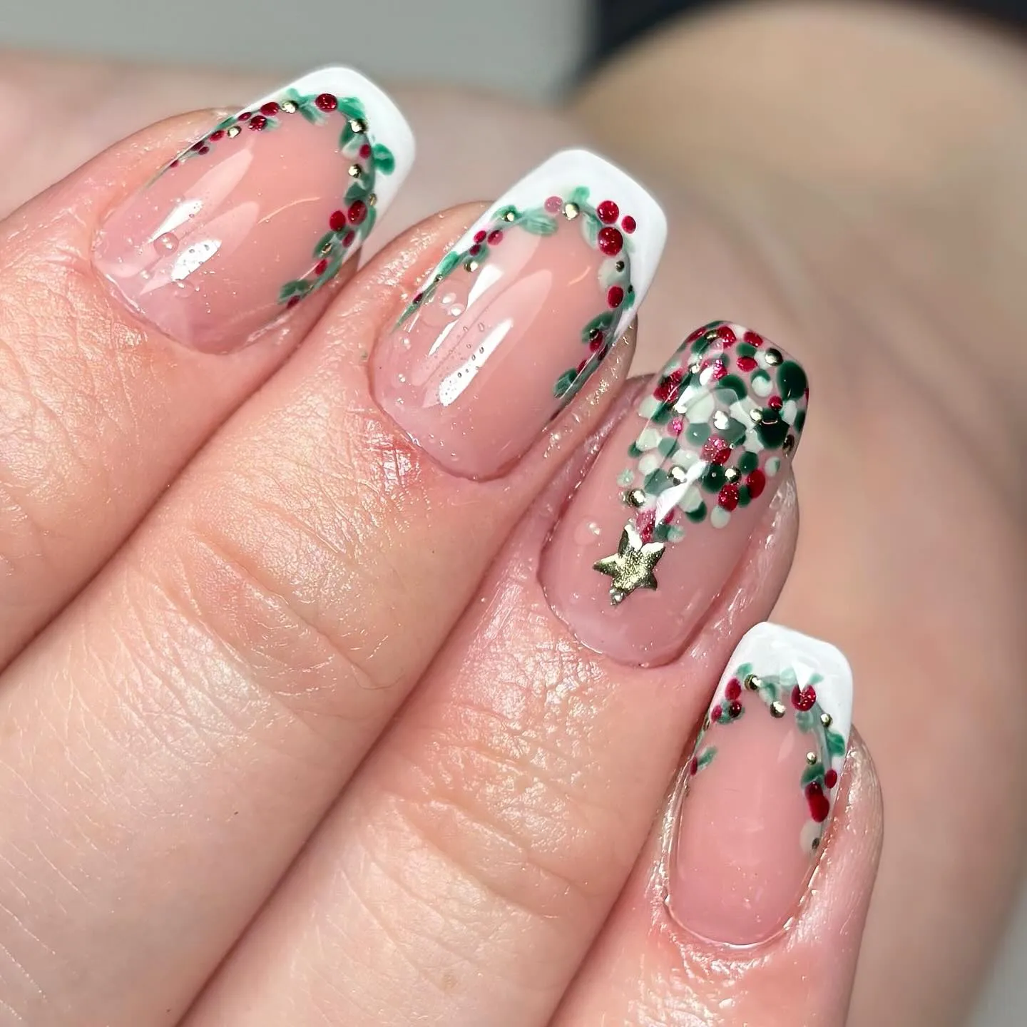 @bytianafaith created the dreamiest Christmas Nails Short design, featuring delicate French tips adorned with wreath-like garlands of red berries and greenery. A little gold star on top makes them look like mini Christmas trees for your fingertips.