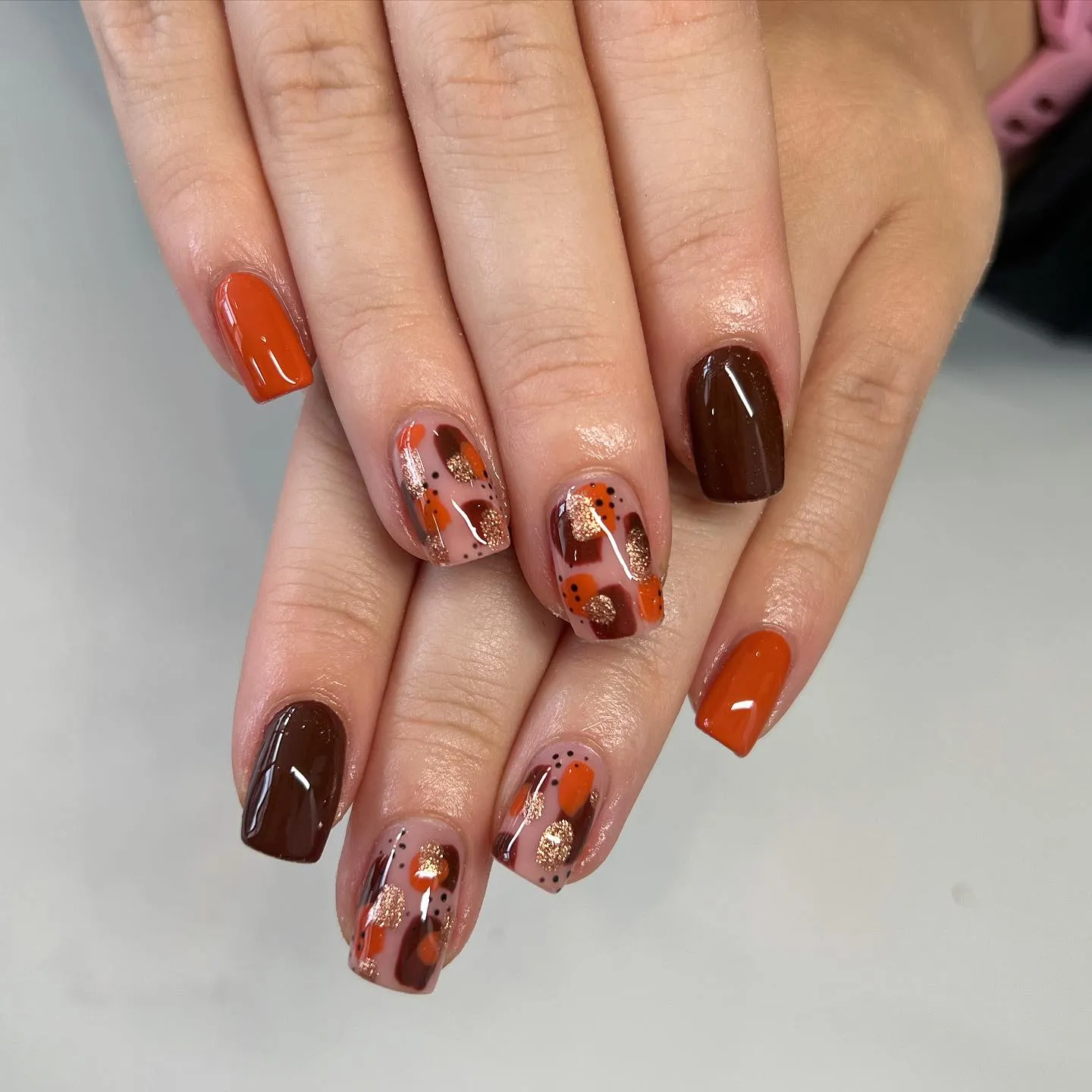 Brown, orange, and gold come together in this glossy mix of swirls and dots. It’s the perfect combination of trendy and timeless for your autumn nails 2025 mood board.