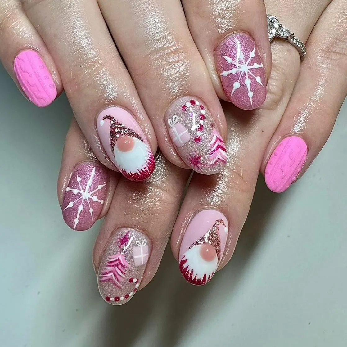 Pink gnomes, tiny gift boxes, and sparkly Christmas trees come together for the cutest pink Christmas nail design. The soft pink and rose shimmer combo makes this one feel cozy yet full of holiday cheer.