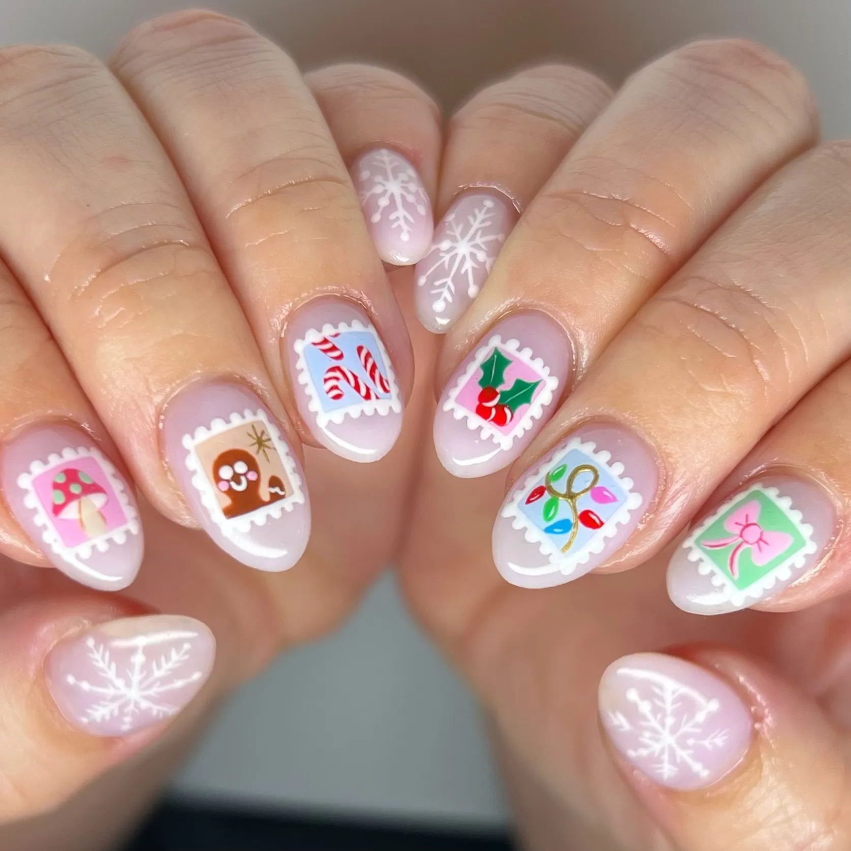 These Christmas stamp nails by @jmoneynails_ are so creative — each one has a mini holiday design framed like a postage stamp. From candy canes to holly and lights, it’s the kind of Christmas themed nail art that makes everyone smile.
