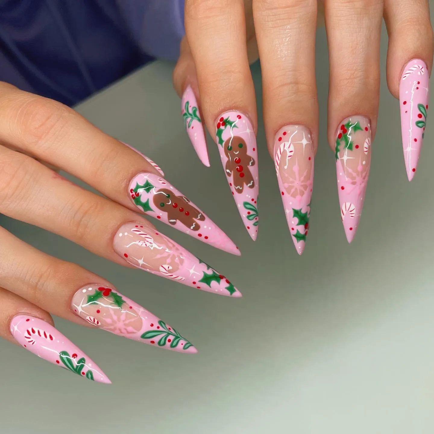 If you love trendy winter nails, this long pink stiletto set is a must-save. With gingerbread cookies, candy canes, and holly leaves, it’s the perfect mix of cute and glam — a true pink Xmas nails moment.