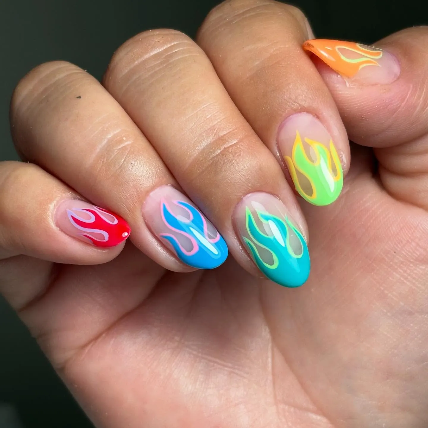 If you like color and confidence, you’ll love this rainbow flame set by @nailsmacsi.cl. Each fingertip features a different neon hue — red, blue, green, yellow — giving instant festival and 2K nails vibes.
