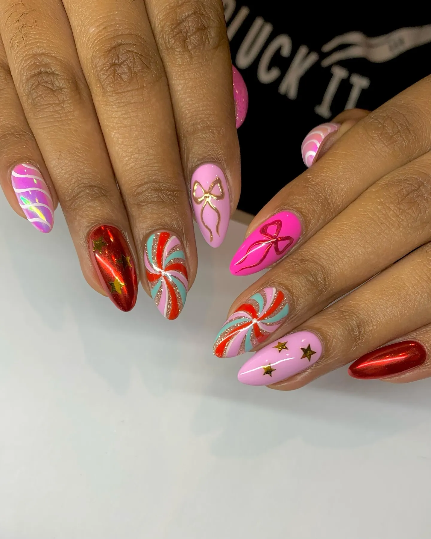 These peppermint swirl pink Christmas nails by @sophrainbownails_ are full of holiday cheer. Bright colors, gold accents, and candy-inspired details make this design the perfect mix of festive and fun.