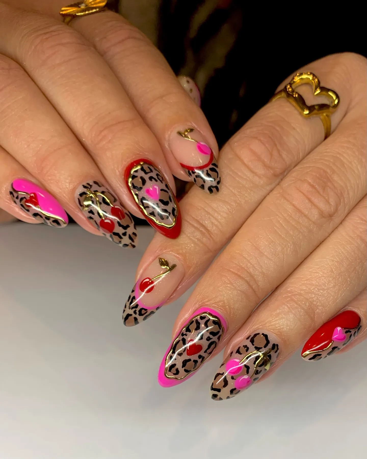 Heart accents and hot pink meet leopard print perfection in this playful love-themed set by @sophrainbownails. The mix of color-blocking, line work, and metallic outlines makes every nail look like a little piece of art.